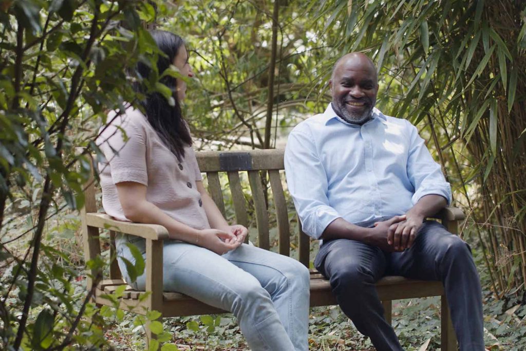 happy-patients-garden-bench-cardinal-clinic Happy male and female patient chatting on garden bench in Cardinal Clinic grounds